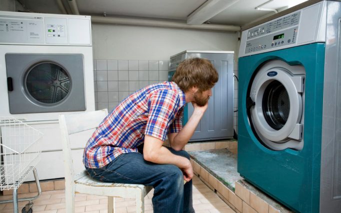 Kille tittar på tvättmaskin